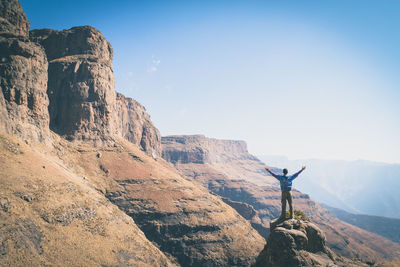 Man on cliff against clear sky