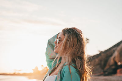 Side view of woman looking away against sky