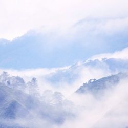 Scenic view of mountains against cloudy sky