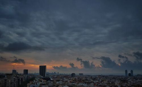 Buildings in city against sky during sunset