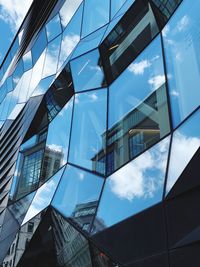 Low angle view of modern glass building against sky