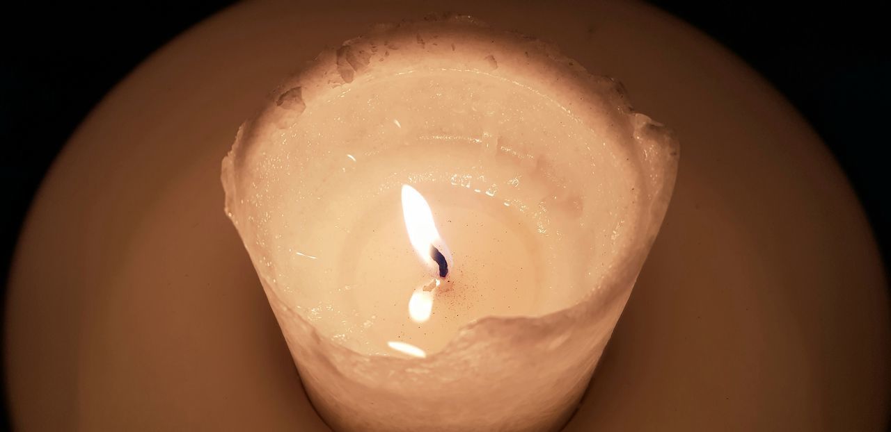 HIGH ANGLE VIEW OF LIT CANDLE IN DARK