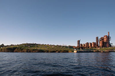 River by buildings against clear sky