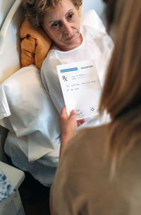 Midsection of woman holding paper with text