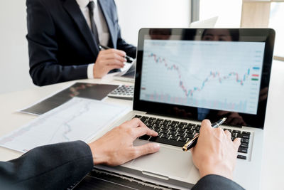Midsection of man using laptop on table