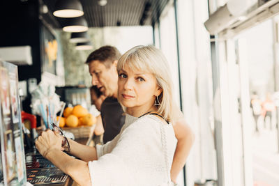 Portrait of woman with husband at cafe