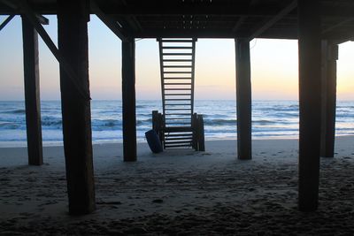 Pier on sea at sunset