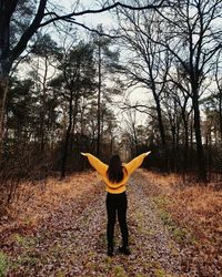 Full length rear view of man standing in forest