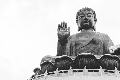 Low angle view of buddha statue against sky