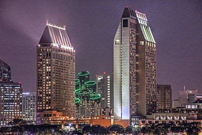 Illuminated buildings against sky at night