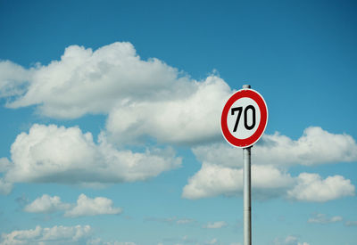 Low angle view of road sign against sky