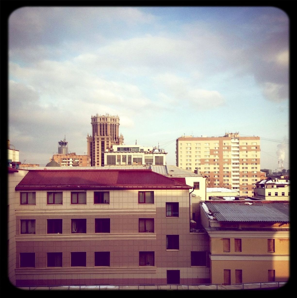 LOW ANGLE VIEW OF BUILDINGS AGAINST CLOUDY SKY