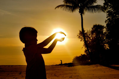 Silhouette of palm trees at sunset