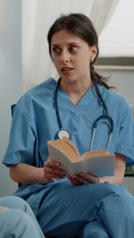 Portrait of female doctor examining patient in hospital