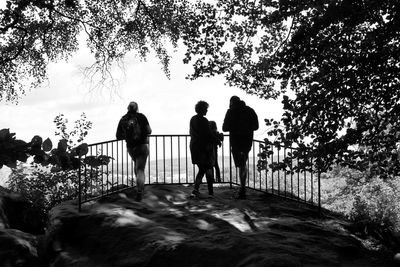 Silhouette people standing on land against sky