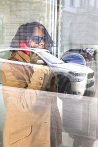 Woman standing with reflection in mirror