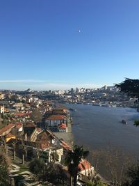 High angle view of townscape by sea against clear sky