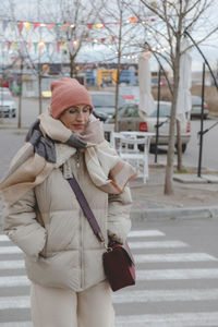 Rear view of young woman standing in city