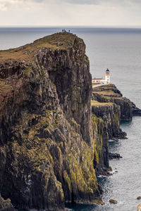 Lighthouse by sea against sky