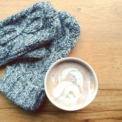 High angle view of hot chocolate by woolen gloves on table