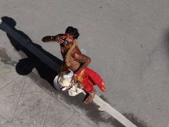 High angle view of shirtless man sitting outdoors