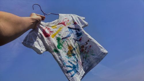 Low angle view of man holding blue sky