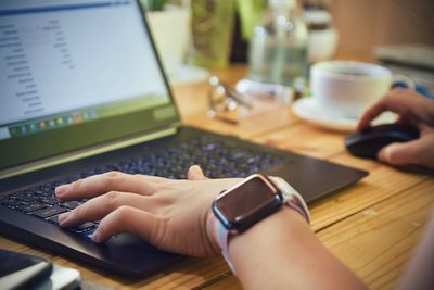 Midsection of man using laptop on table