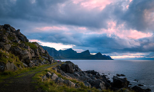 Scenic, dirt road along the beach against the sunset mountain view, against sky, lofoten, norway