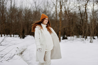 Young woman standing on snow covered field