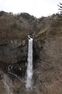 Scenic view of waterfall against sky