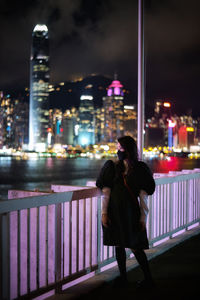 Rear view of woman walking on street at night