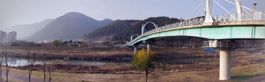 Bridge over river with mountain range in background