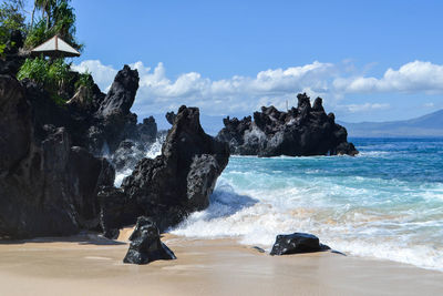 Scenic view of rocks on beach against sky