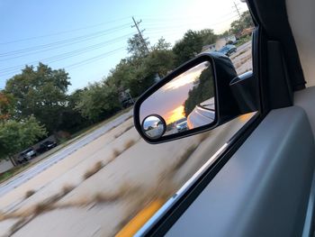 View of side-view mirror against sky