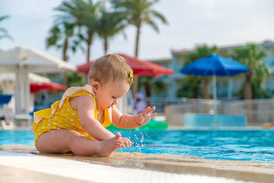 Cute baby splashing in swimming pool