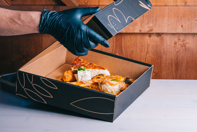 Midsection of person holding food on table