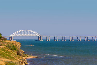 Bridge over sea against clear sky