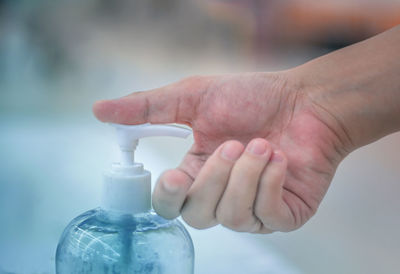 Close-up of hand holding glass bottle