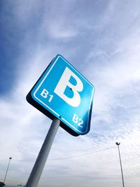 Low angle view of road sign against blue sky