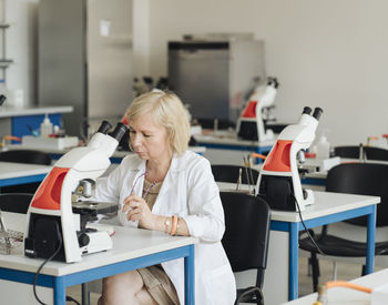 Senior female researcher in a white coat working in lab
