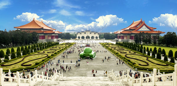 People at town square against cloudy sky