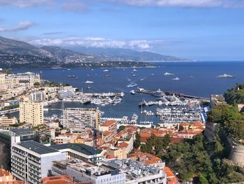 High angle view of city by sea against sky