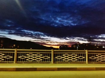 Illuminated railing against sky at night