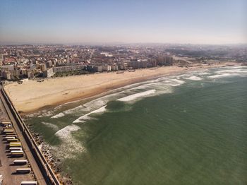 High angle view of buildings by sea against sky