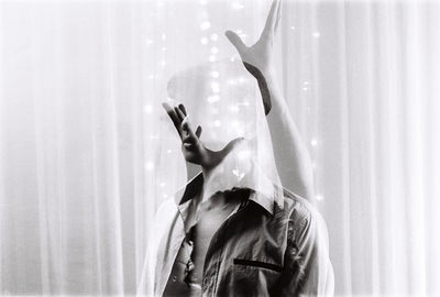 Double exposure of man and woman against curtain