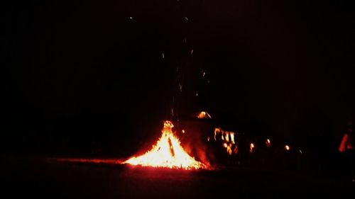 Illuminated bonfire against clear sky at night