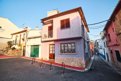 Houses by street in town against sky