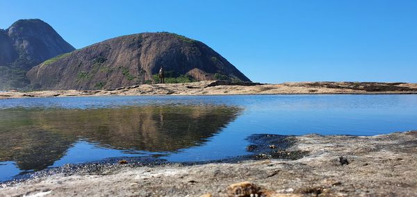 Scenic view of rocks against clear blue sky