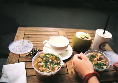 Cropped image of person having food at restaurant table