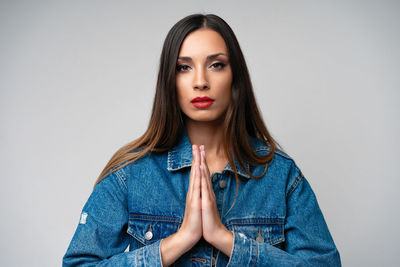 Portrait of beautiful young woman against white background